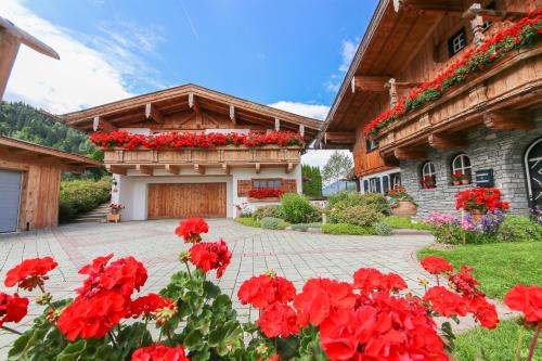 a house with red flowers in front of it at Chalet Eder in Leogang