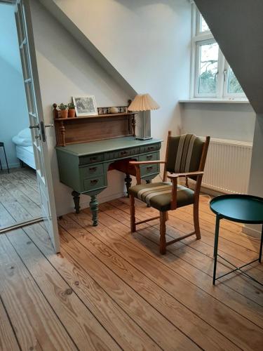 un piano viejo y una silla en una habitación en LatterLy Rooms en Silkeborg