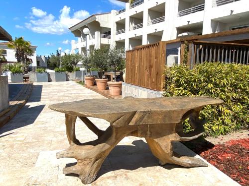 a wooden bench sitting in front of a building at Bella Vista Hôtel, Suites & Maisons in Porticcio