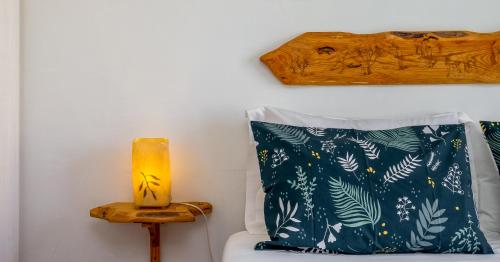 a bed with two pillows and a lamp on a table at Monte do Giestal - Casas de Campo & Spa in Abela