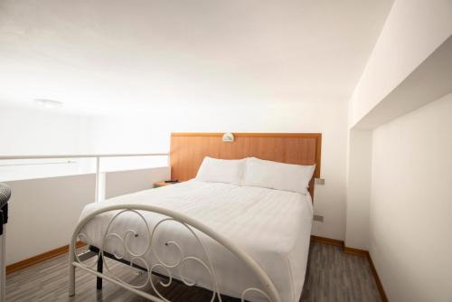 a bedroom with a white bed with a wooden headboard at Il Conero Mare in Numana