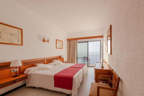 a hotel room with a bed and a balcony at Hostal Sa Baronia in Banyalbufar