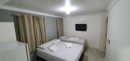 a small room with a bed and a television at Pousada Veleiro in Fortaleza