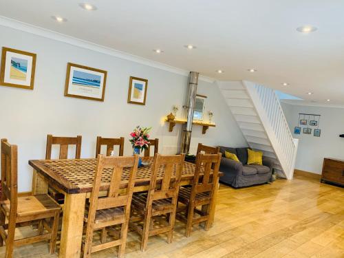 a dining room with a table and chairs and a staircase at Shepherds House in Swanage