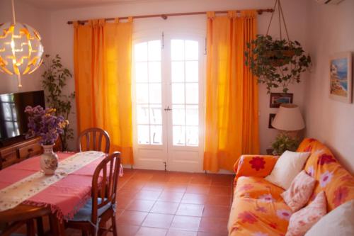 sala de estar con mesa y sofá en Homenfun Menorca Playa de Fornells II, en Fornells