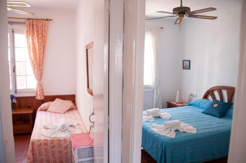 una camera con 2 letti e un ventilatore a soffitto di Homenfun Menorca Playa de Fornells II a Fornells