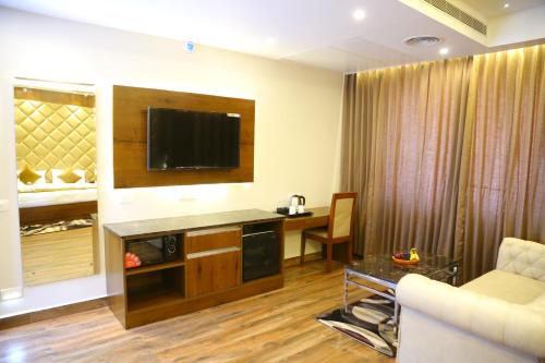 a living room with a television on a wall at VSR GRAND in Madanapalle