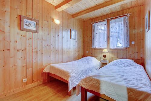 Cette chambre en bois dispose de 2 lits et d'une fenêtre. dans l'établissement LES SERMES M304, à Morzine