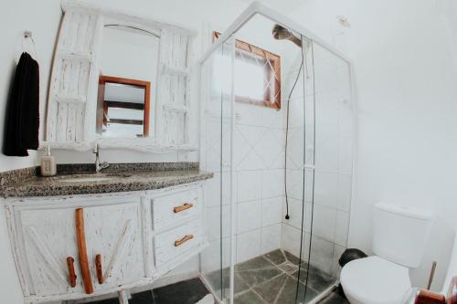 a bathroom with a sink and a glass shower at Guarda do Embaú Aluguél Casa 300mts Praia in Guarda do Embaú