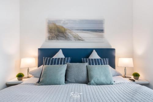 a bedroom with a blue and white bed with pillows at Dock 76 Bridge - Penthouse in Olpenitz