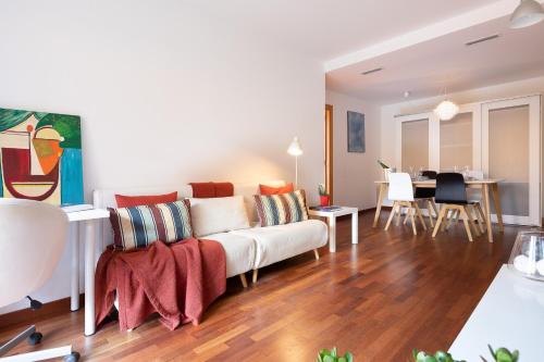 Lets Holidays Terrace Barcelona في برشلونة: غرفة معيشة مع أريكة بيضاء وطاولة