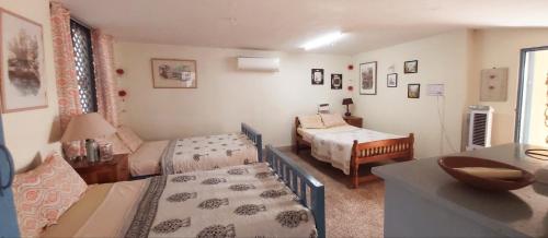 a bedroom with two beds and a table with a desk at VILLA SANDRIN-Near White Town and Beach in Puducherry