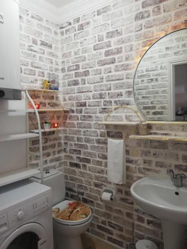 a bathroom with a brick wall with a toilet and a sink at Sea view Bougainvillea 52 in Kalkan