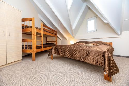 ein Schlafzimmer mit einem Etagenbett und einer Leiter in der Unterkunft Apartamentai Upė in Šventoji
