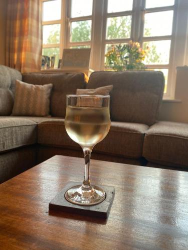 a glass of wine sitting on a table at Relaxing townhouse in the heart of Bridport in Bridport