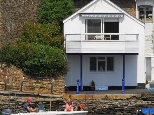 a man and a girl in a boat in front of a house at The Boathouse in Kingsbridge