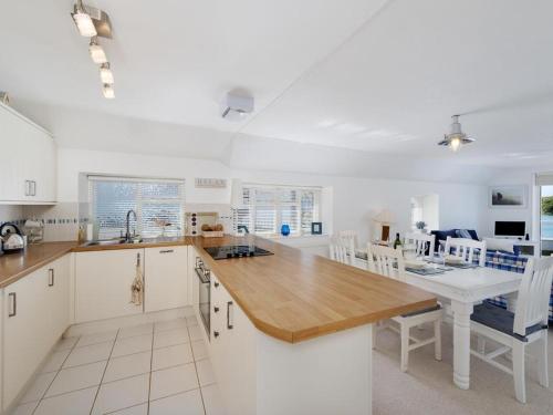 a kitchen with white cabinets and a wooden counter top at The Boathouse in Kingsbridge