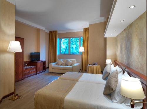 a hotel room with a large bed and a couch at Windsor Hotel Milano in Milan