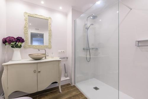 biała łazienka z umywalką i prysznicem w obiekcie Colon Zurriola IB Apartments w mieście San Sebastián
