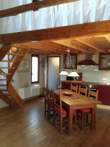 a kitchen and dining room with a wooden table and chairs at Gîte Montrias in Cerfontaine