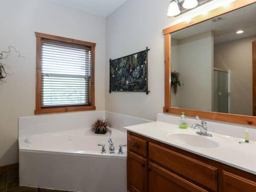 a bathroom with a tub and a sink and a mirror at Lodge 371 in Branson