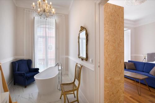 a living room with a blue couch and a tub at 1869 Príncipe Real House in Lisbon