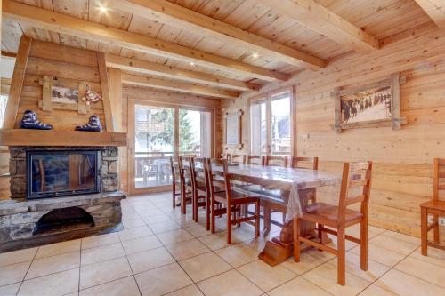 une salle à manger avec une cheminée, une table et des chaises dans l'établissement LES SERMES M504, à Morzine