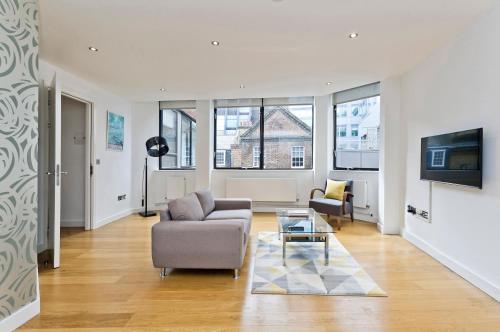 a living room with a couch and a table at Red Lion Court by City2Stay in London