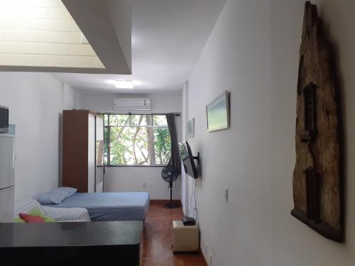 um pequeno quarto com uma cama e uma janela em Ipanema Paz e Amor no Rio de Janeiro