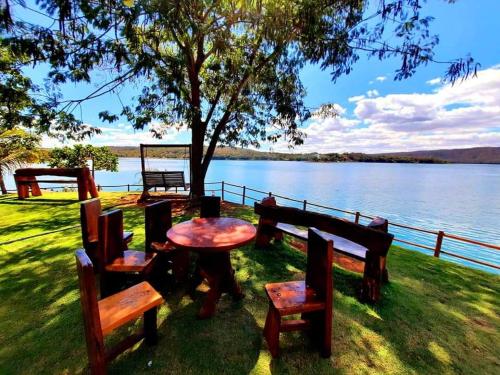 a table and chairs sitting next to a lake at Aldeia Do Lago ,304.caldas novas in Caldas Novas