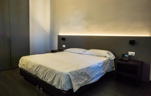 1 dormitorio con 1 cama grande y 2 mesitas de noche en Venice Terminal Apartments & Suites en Mestre