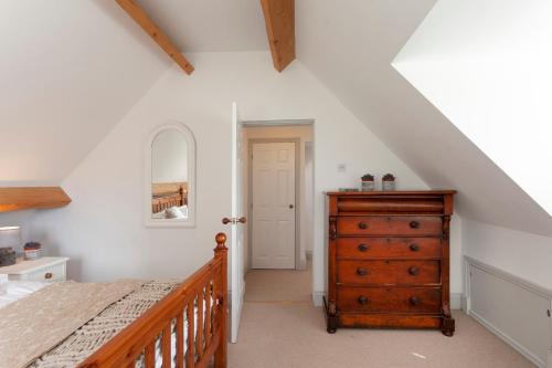 a bedroom with a bed and a wooden dresser at Quorn Farmhouse in Quorndon