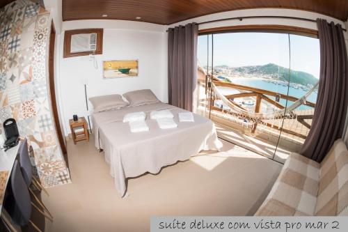 a hotel room with a bed and a window at Cantinho dos Anjos Suítes in Arraial do Cabo