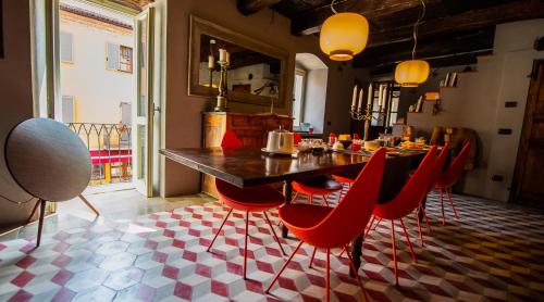 a dining room with a table and red chairs at Boutique Hotel Al Palazzo Rosso in Neive