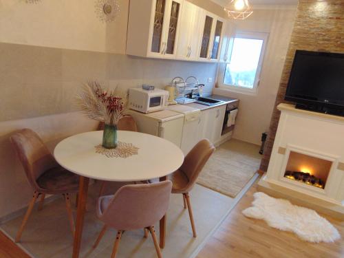 a kitchen with a table and chairs and a fireplace at Apartman Magic Zlatibor-Čajetina in Čajetina