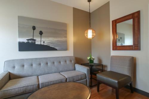 a living room with a couch and a table at Oxford Suites Pismo Beach in Pismo Beach