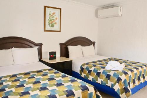 a hotel room with two beds in a room at Hotel El Cid in Mérida