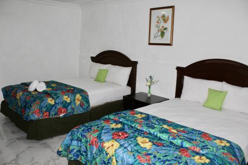 a hotel room with two beds at Hotel El Cid in Mérida