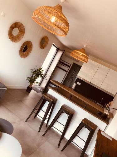 - un salon avec une table et quelques tabourets dans l'établissement Les Mégalithes, à Sète