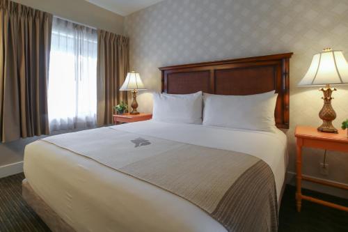 a hotel room with a large bed and a window at Oxford Suites Pismo Beach in Pismo Beach