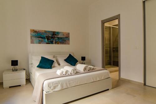 a bedroom with a bed with blue pillows at Chez moi in Siracusa