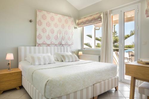 a bedroom with a large bed and a window at Panorama Fanari studios and apartments in Argostoli