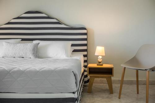 a bedroom with a bed and a table with a lamp at Panorama Fanari studios and apartments in Argostoli