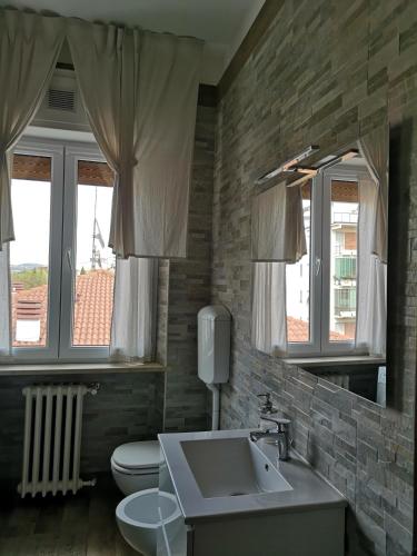 a bathroom with a sink and a toilet and windows at Queen East Verona apartments in Verona
