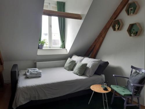 um pequeno quarto com uma cama e uma janela em Studio Hugo em Nijmegen