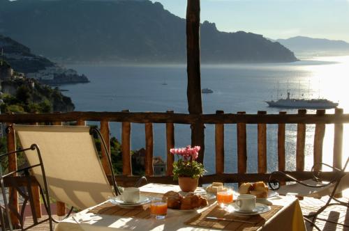 a table with food and a view of the water at Villa Alba d'Oro - Historic luxury villa in Amalfi