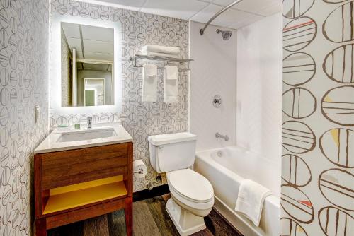 a bathroom with a toilet and a sink and a tub at Holiday Inn East Windsor, an IHG Hotel in Hightstown