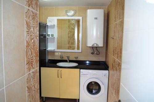 a small bathroom with a washing machine and a sink at Antalya belek green park golf apart ground floor 2 bedrooms close the beach park in Belek