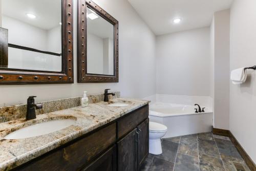 a bathroom with a sink and a toilet and a mirror at Lodge 73 in Branson