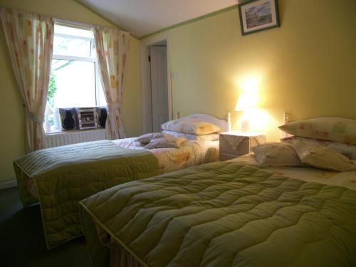 a hotel room with two beds and a window at Achill View B&B in Murrisk